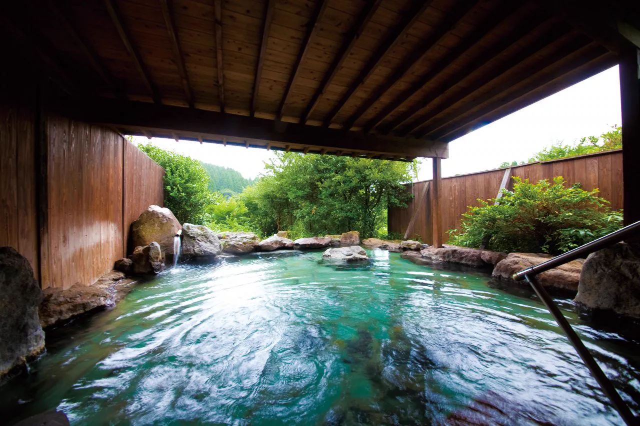 Open-air hot-spring bath at Yufuin Gettouan among the trees