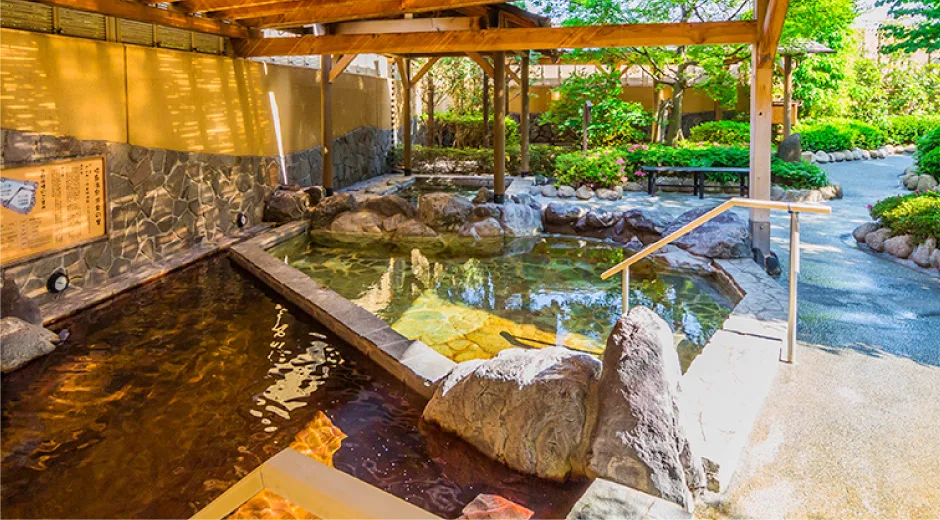 Garden greenery around the outdoor baths at Akishima Onsen Yuraku no Sato